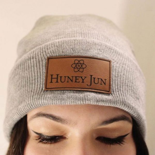 Woman wearing a gray beanie with a Huney Jun leather patch