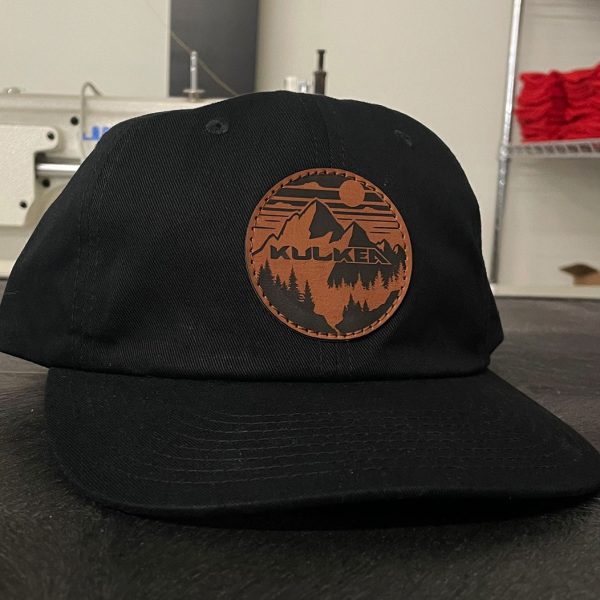 Black hat with a round Kulkea leather patch