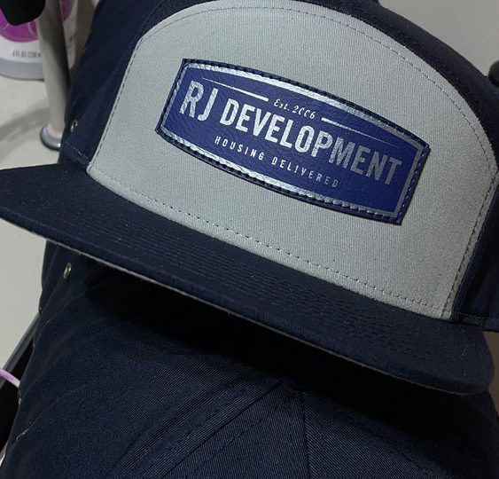 Navy hats with an RJ Development faux leather patch